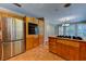Spacious kitchen with stainless steel refrigerator, wooden cabinets and island gas cooktop at 7100 Carrondale Way, Las Vegas, NV 89128