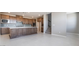 Open-concept kitchen featuring wooden cabinetry, stainless appliances, tile flooring and access to stairs at 769 Cloud Creek St, Henderson, NV 89011