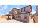 Back view of a two-story house with covered patio, red tile roof and sandy backyard at 769 Cloud Creek St, Henderson, NV 89011