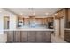 Spacious kitchen featuring an island, wooden cabinets, stainless steel appliances, and tiled backsplash at 769 Cloud Creek St, Henderson, NV 89011