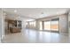 Expansive living room with access to the backyard, open kitchen and neutral tile flooring at 769 Cloud Creek St, Henderson, NV 89011