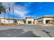 Lovely exterior of the Sun City Allante building, with a circular driveway, desert landscaping and flags at 7916 Lyrebird Dr, North Las Vegas, NV 89084