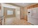 Open kitchen area features white appliances, wooden cabinetry, and neutral tile flooring at 7916 Lyrebird Dr, North Las Vegas, NV 89084