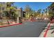 Gated community entrance featuring well-maintained landscaping, a secure gate, and mature trees at 7950 W Flamingo Rd # 1042, Las Vegas, NV 89147