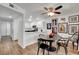 Well-lit dining area with a modern ceiling fan, complemented by an open kitchen design and unique wall art at 7950 W Flamingo Rd # 1042, Las Vegas, NV 89147