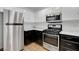 Stainless steel refrigerator and gas range stove with black and white cabinets at 7950 W Flamingo Rd # 1042, Las Vegas, NV 89147