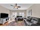 Spacious living room with a ceiling fan, sleek furniture, wood floors, and sliding glass doors leading to the outdoor patio at 8139 Skytop Ledge Ave, Las Vegas, NV 89178