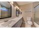 Bathroom featuring a long countertop with double sinks, vanity lights, and glass enclosed shower at 8729 Pesaro Dr, Las Vegas, NV 89117
