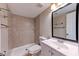 Well-lit bathroom featuring a shower with tile surround, toilet, and vanity with mirror and lighting at 8729 Pesaro Dr, Las Vegas, NV 89117