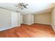 Spacious bedroom with beautiful hardwood floors, neutral paint, ceiling fan and multiple doors at 8729 Pesaro Dr, Las Vegas, NV 89117