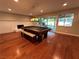 Spacious game room featuring a pool table, brick fireplace, wood floors, and backyard access at 8729 Pesaro Dr, Las Vegas, NV 89117
