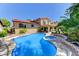 A beautiful pool with a raised jacuzzi, nestled in a lush tropical landscape at 8729 Pesaro Dr, Las Vegas, NV 89117