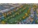 An aerial view showcases lush golf course, mature trees, and surrounding townhomes and commercial area at 882 Tam O Shanter, Las Vegas, NV 89109