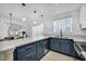 Updated kitchen boasts blue cabinets, quartz countertops, stainless steel appliances, and modern pendant lighting at 882 Tam O Shanter, Las Vegas, NV 89109
