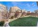 Landscaped backyard with artificial turf, mature trees, and privacy wall at 9850 Poplar Point Ave, Las Vegas, NV 89178
