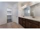 Bathroom featuring a double vanity with dark wood cabinets, tile flooring, and a view into the closet at 9850 Poplar Point Ave, Las Vegas, NV 89178
