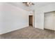Spacious bedroom featuring neutral walls, plush carpeting, closet with sliding doors, and a ceiling fan at 9850 Poplar Point Ave, Las Vegas, NV 89178