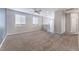Spacious living room with neutral walls, plush carpeting, and lots of natural light streaming in through two large windows at 9850 Poplar Point Ave, Las Vegas, NV 89178