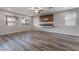 Spacious living room boasts wood-look floors, large windows, and a modern media console at 9850 Poplar Point Ave, Las Vegas, NV 89178