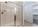 Modern tiled shower with glass doors, complemented by a neutral color scheme and tile flooring at 9850 Poplar Point Ave, Las Vegas, NV 89178