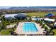 Aerial view of a community pool with lounge chairs, splash pad, recreation center and green spaces at 10160 Tree Blossom Ave, Las Vegas, NV 89166