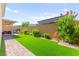 Spacious backyard with artificial turf, brick pathway, and covered patio that creates perfect space for gatherings at 10160 Tree Blossom Ave, Las Vegas, NV 89166