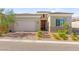 Charming single-story home featuring stone accents, a brick driveway, and a two-car garage at 10160 Tree Blossom Ave, Las Vegas, NV 89166