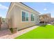 Side yard with artificial grass, brick pathway, and gate, offers privacy and functional outdoor space at 10160 Tree Blossom Ave, Las Vegas, NV 89166