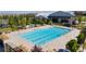 Aerial view of a community pool with lounge chairs, landscaping, and a recreation center at 10160 Tree Blossom Ave, Las Vegas, NV 89166