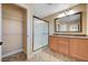 Well-lit bathroom featuring a double sink vanity, walk-in shower, and a spacious closet with shelving at 10343 Beallsville St, Las Vegas, NV 89141