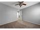 Neutral bedroom with a ceiling fan, carpeting, and a door to another room, perfect for relaxing at 10343 Beallsville St, Las Vegas, NV 89141