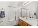 Bright bathroom features a shower over tub with glass doors and wooden cabinets at 10352 Natural Springs Ave, Las Vegas, NV 89129