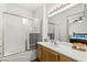 Well-lit bathroom features shower over tub, bright white tiling, and warm wooden cabinets at 10352 Natural Springs Ave, Las Vegas, NV 89129