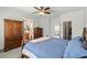 Bright bedroom featuring neutral paint, ceiling fan, wood furnishings, and access to an en-suite bathroom at 10352 Natural Springs Ave, Las Vegas, NV 89129