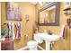 Cozy half-bathroom with decorative mirror, vanity, sink, and toilet at 1228 Swanbrooke Dr, Las Vegas, NV 89144
