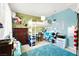 A colorful bedroom featuring a loft bed, desk, drawers, and many decorations at 1228 Swanbrooke Dr, Las Vegas, NV 89144