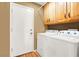 Clean laundry room with white washer and dryer units, as well as upper cabinets at 1228 Swanbrooke Dr, Las Vegas, NV 89144