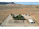 Aerial view of desert property featuring fenced backyard and outbuildings at 12992 State Hwy 160, Las Vegas, NV 89161