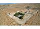 Wide aerial view of a desert home, showcasing a fenced yard, mature trees, and surrounding open space at 12992 State Hwy 160, Las Vegas, NV 89161