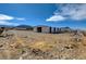Equestrian barn with paddocks featuring durable construction and mountain views against a blue sky at 12992 State Hwy 160, Las Vegas, NV 89161
