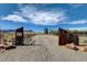 Private property entrance featuring custom wooden gate with wagon wheel accents and desert landscape at 12992 State Hwy 160, Las Vegas, NV 89161