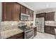 Modern kitchen with stainless steel appliances, granite countertops, and dark wood cabinets at 1304 Fantastic Ct, North Las Vegas, NV 89081