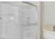 All-white shower featuring glass door, built-in seat, shelving and bright lighting at 1304 Fantastic Ct, North Las Vegas, NV 89081