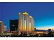 Stunning exterior view of a high-rise building with illuminated accents against a vibrant night sky at 135 E Harmon Ave # 2702, Las Vegas, NV 89109
