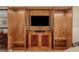 Elegant wood entertainment center with display shelves, closed storage, and a sleek, built-in television at 135 E Harmon Ave # 2702, Las Vegas, NV 89109