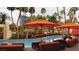 Inviting pool area featuring comfortable lounge chairs, vibrant orange umbrellas, and lush palm trees at 135 E Harmon Ave # 2702, Las Vegas, NV 89109