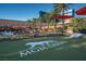 Outdoor recreation area with lush green grass, palm trees, and games for entertainment at 135 E Harmon Ave # 2702, Las Vegas, NV 89109