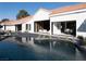 An exquisite backyard showcasing a modern pool and pristine desert landscaping against a bright white home at 1429 Iron Hills Ln, Las Vegas, NV 89134