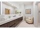 Bright bathroom with quartz counters, wood cabinetry, and a decorative chair at 1429 Iron Hills Ln, Las Vegas, NV 89134