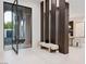 The front entrance features a modern design, a sitting area, and views through a large glass door to the front yard at 1429 Iron Hills Ln, Las Vegas, NV 89134